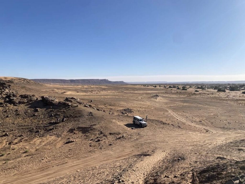 Aerial view of our Jeep on the desert 4x4 track with mountains in the background on the way to the Lost City of Bah Haoudou in Morocco