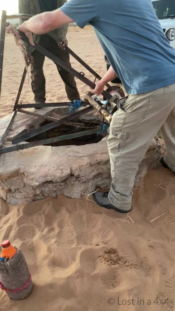Brett and the camel herder finishing restoring the safety structure on the desert well after the baby camel rescue in Morocco