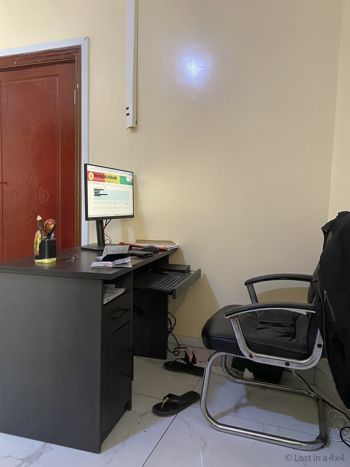 Visa officer entering our information into the system during our in-person Guinea (Conakry) visa application in Dakar