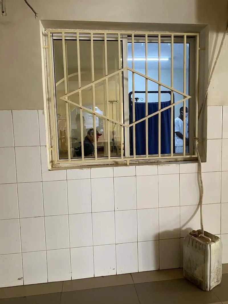 Brett inside emergency room viewed from outside the window at Hôpital de la Paix in Ziguinchor Senegal before epinephrine shot