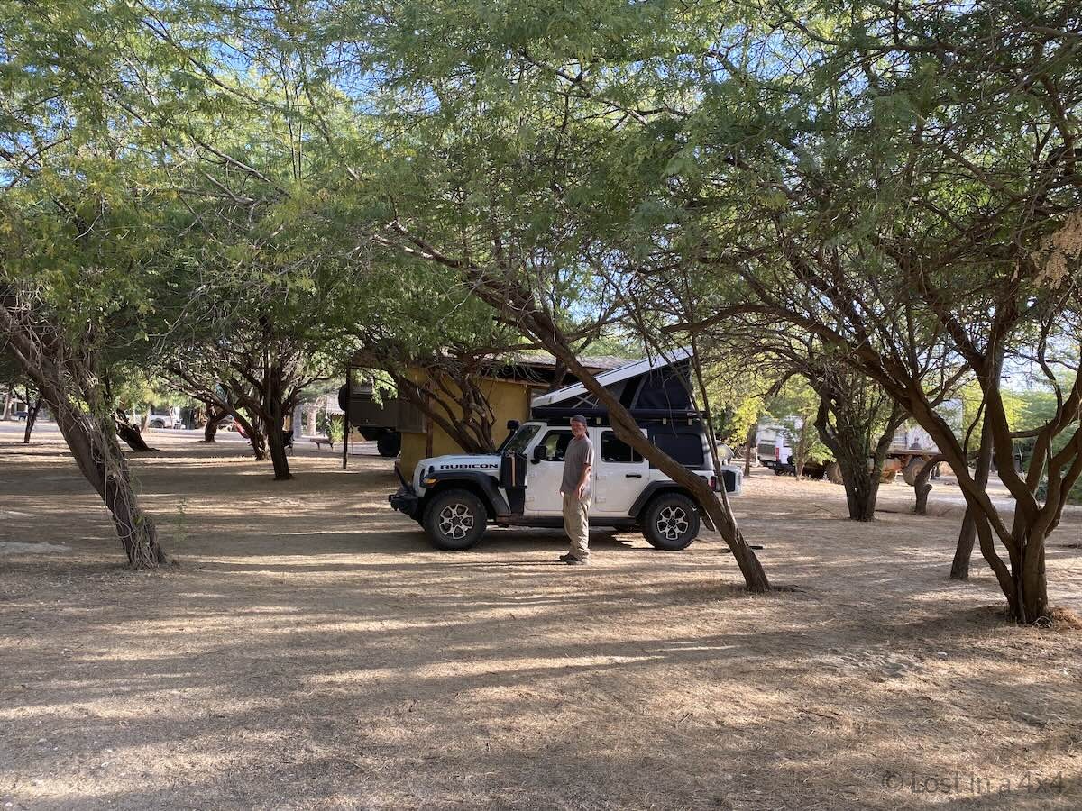 Brett standing next to a Jeep with an Ursa Minor roof top tent set up at Zebra Bar Camping in Senegal