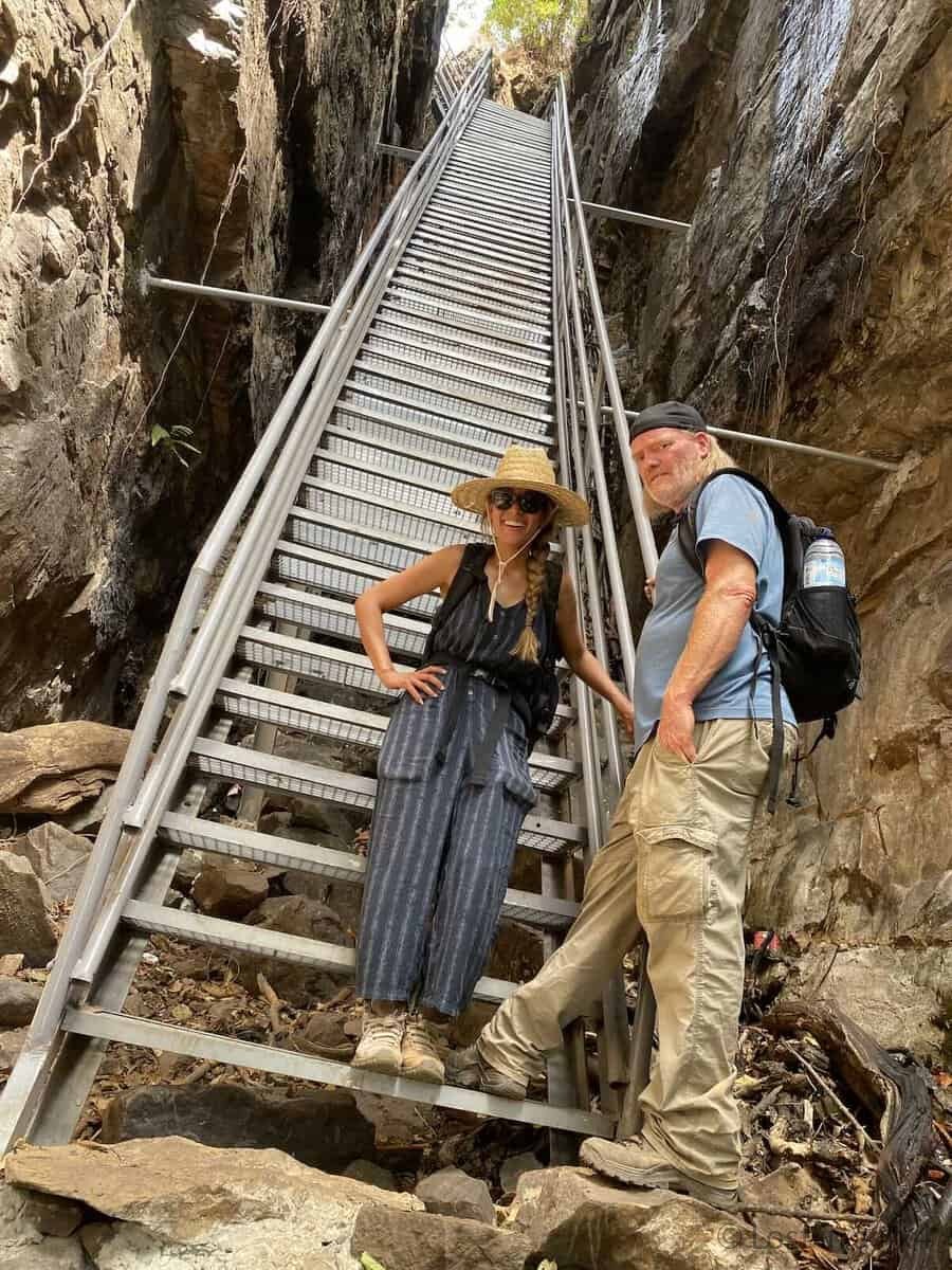 Brett and Karla standing at the bottom of the modern stairs at Les Échelles de Djinkan in Guinea.