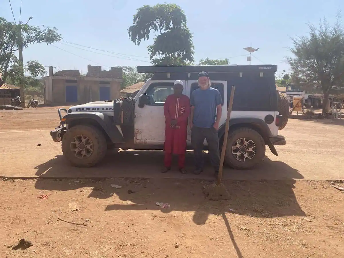 Brett with the mayor of Browal Tappe standing in front of Jeep Wrangler Rubicon in Guinea