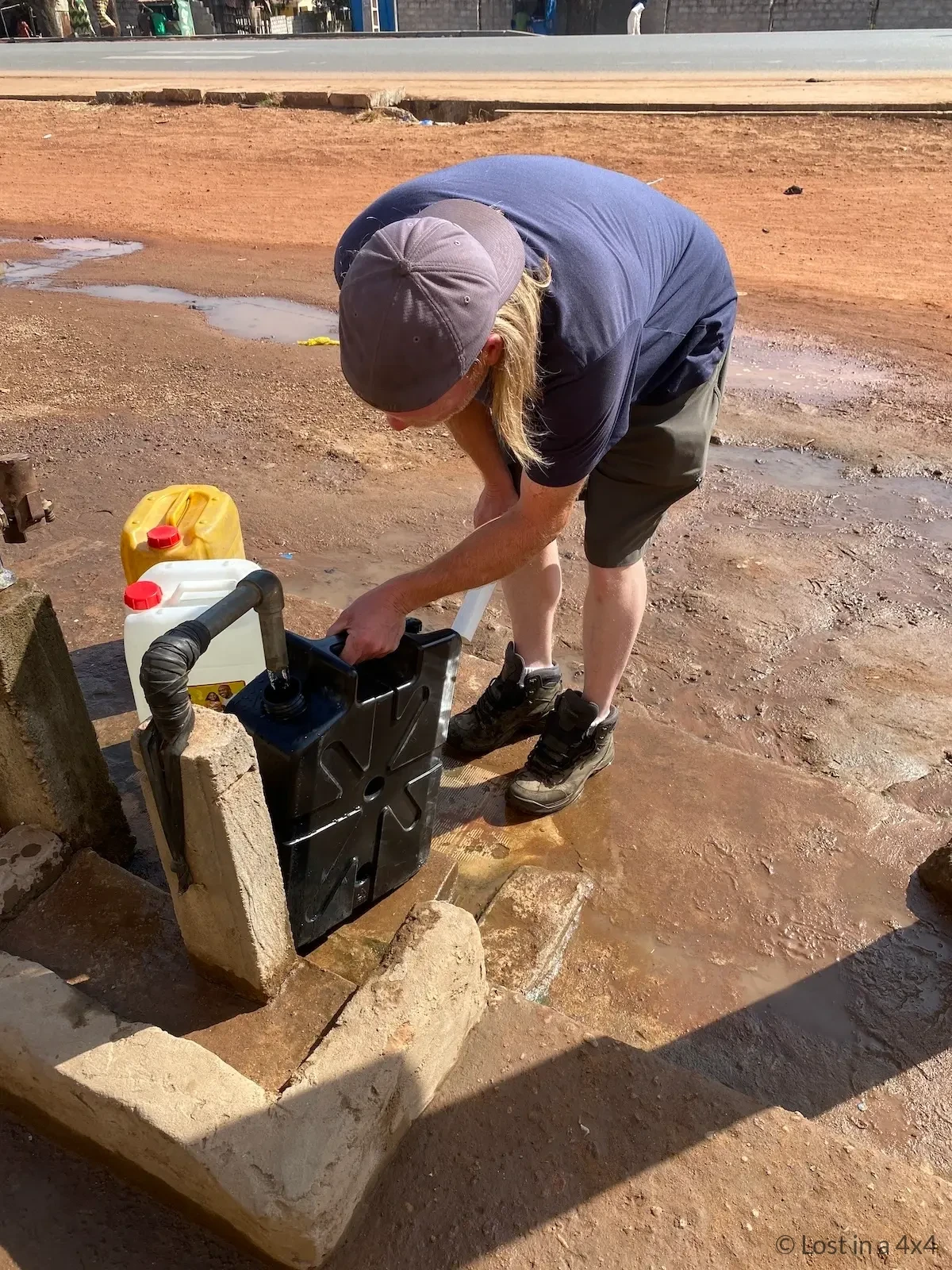 Brett refilling LifeSaver Jerrycan water filter in an African town during overland travel