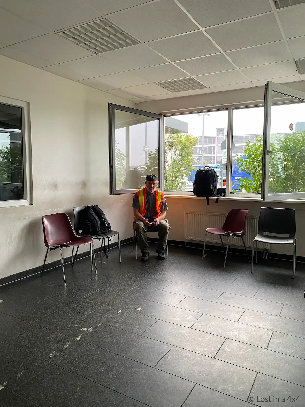 Brett sitting inside Unikai port office in Hamburg wearing high visibility vest while waiting to pick up Jeep