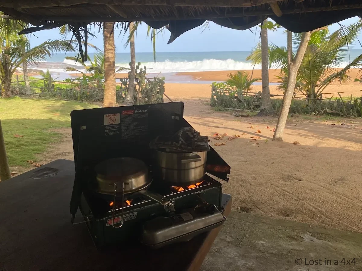 Coleman 424 dual-fuel camp stove cooking at beach in Ivory Coast with pot 