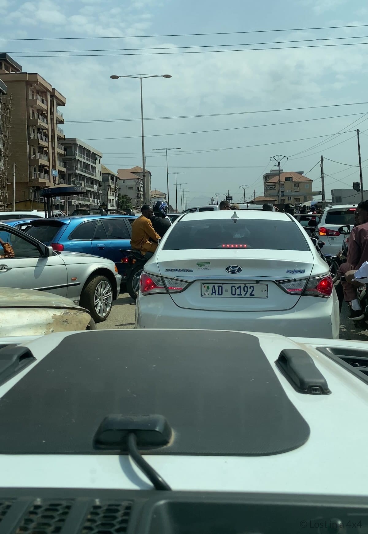Heavy traffic in Conakry, Guinea seen from inside a Jeep Wrangler during an overland journey through West Africa.