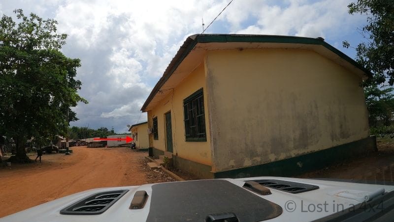 View from inside of the Jeep Wrangler through the windshield approaching the Côte d’Ivoire customs office during border crossing from Liberia.