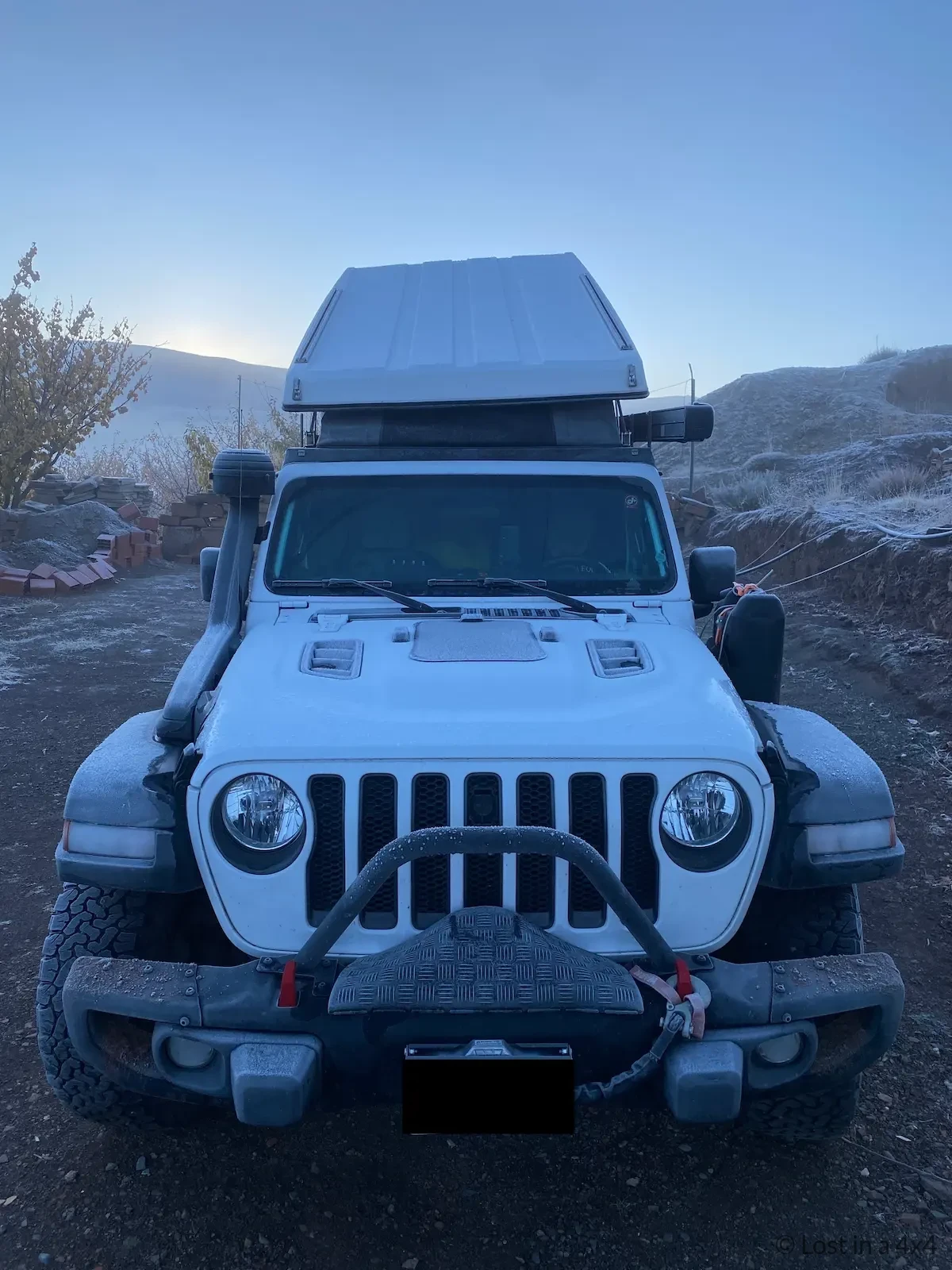 Frozen Jeep Wrangler Rubicon with Ursa Minor rooftop tent after a cold night in Imilchil, Morocco, showing harsh weather challenges during overland travel.