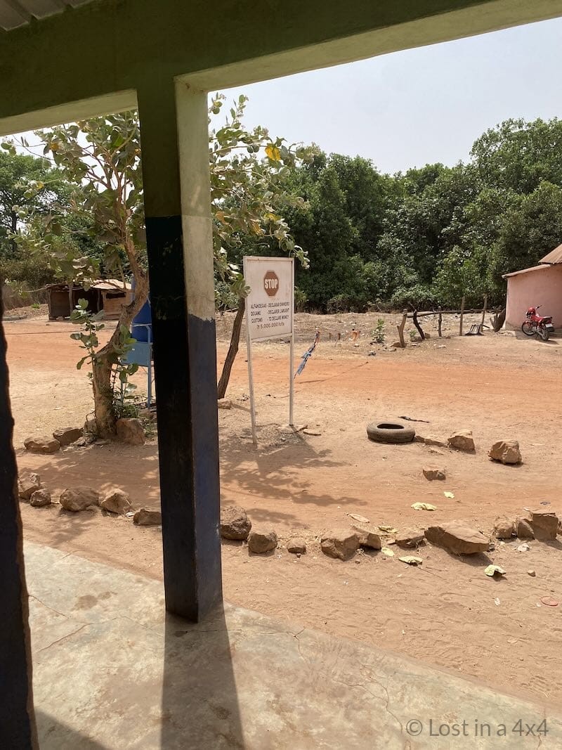 Stop sign and final roadblock at the Guinea-Bissau border post before exiting into Guinea.