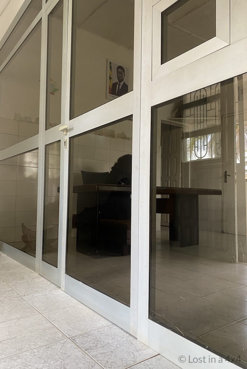 Inside the Consulate of Guinea-Bissau in Ziguinchor, Senegal where travelers complete the visa application process during an overland journey through West Africa.