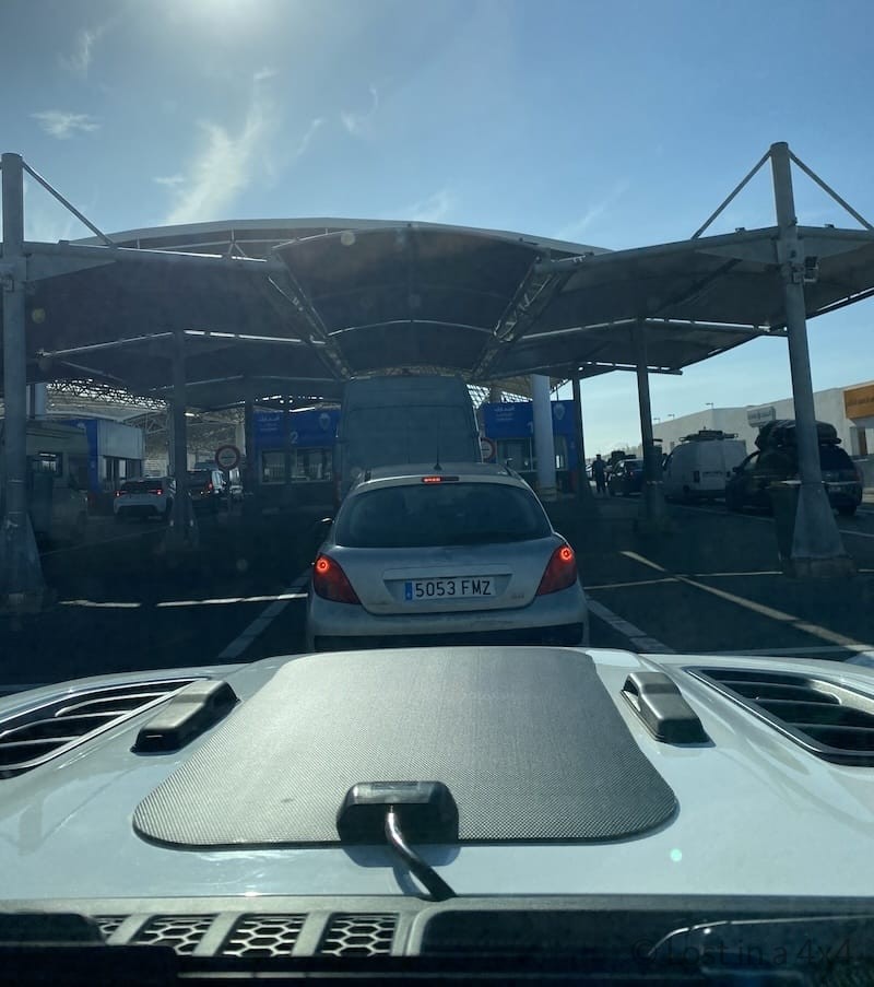 View from inside a Jeep through the windshield showing the customs queue at Tangier Med port in Morocco