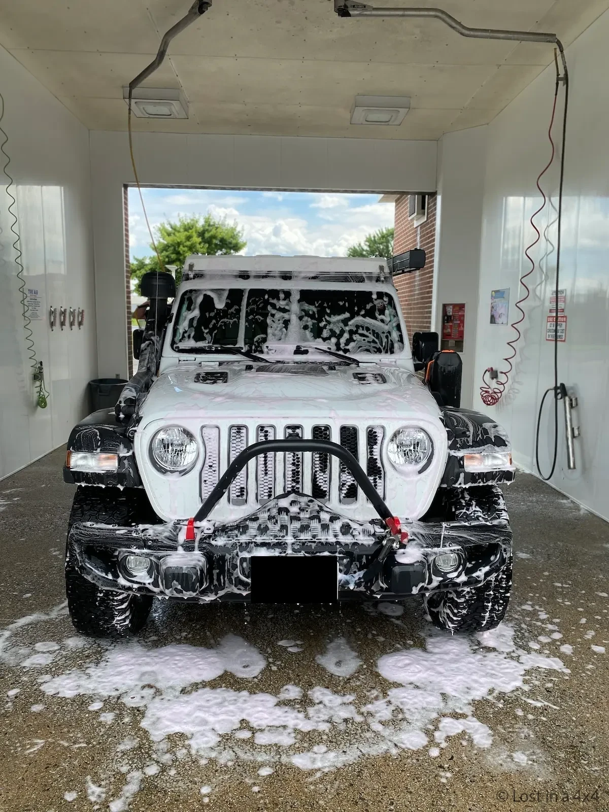 Jeep overland rig being washed at manual car wash while preparing for shipping from USA to Europe