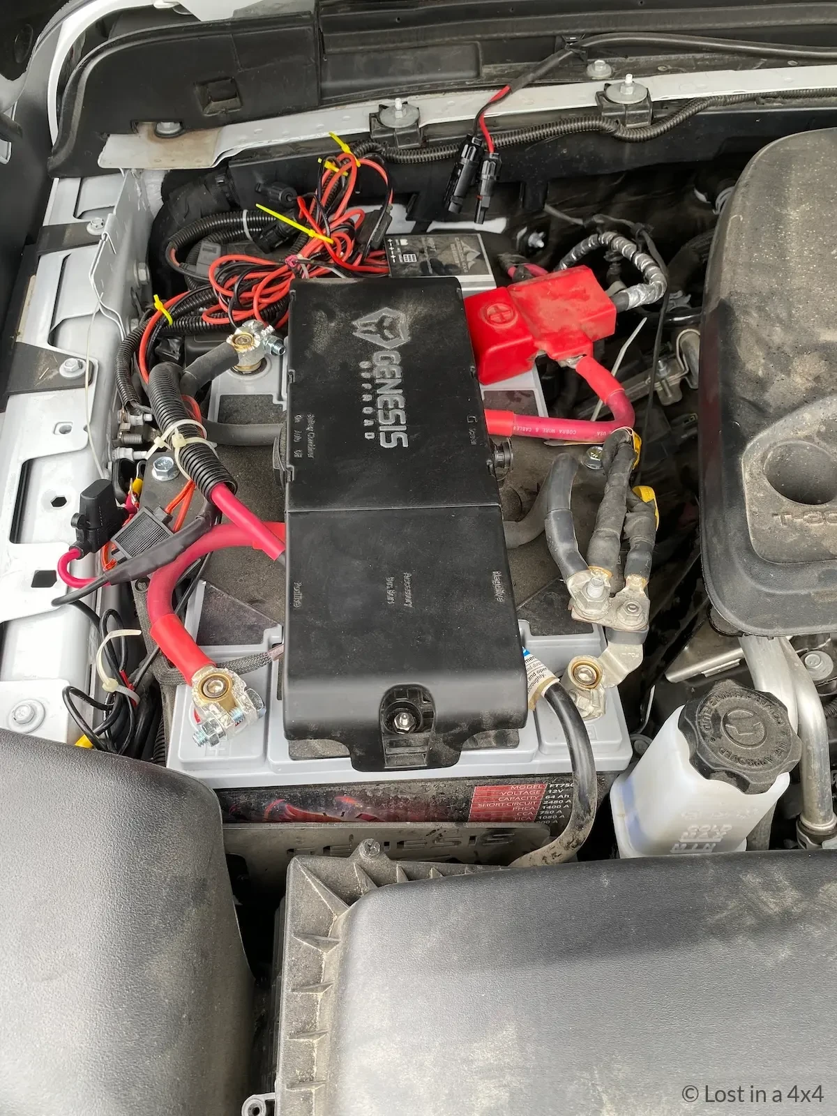 Jeep dual battery system under hood with solar panel connected during preparation for shipping from USA to Europe