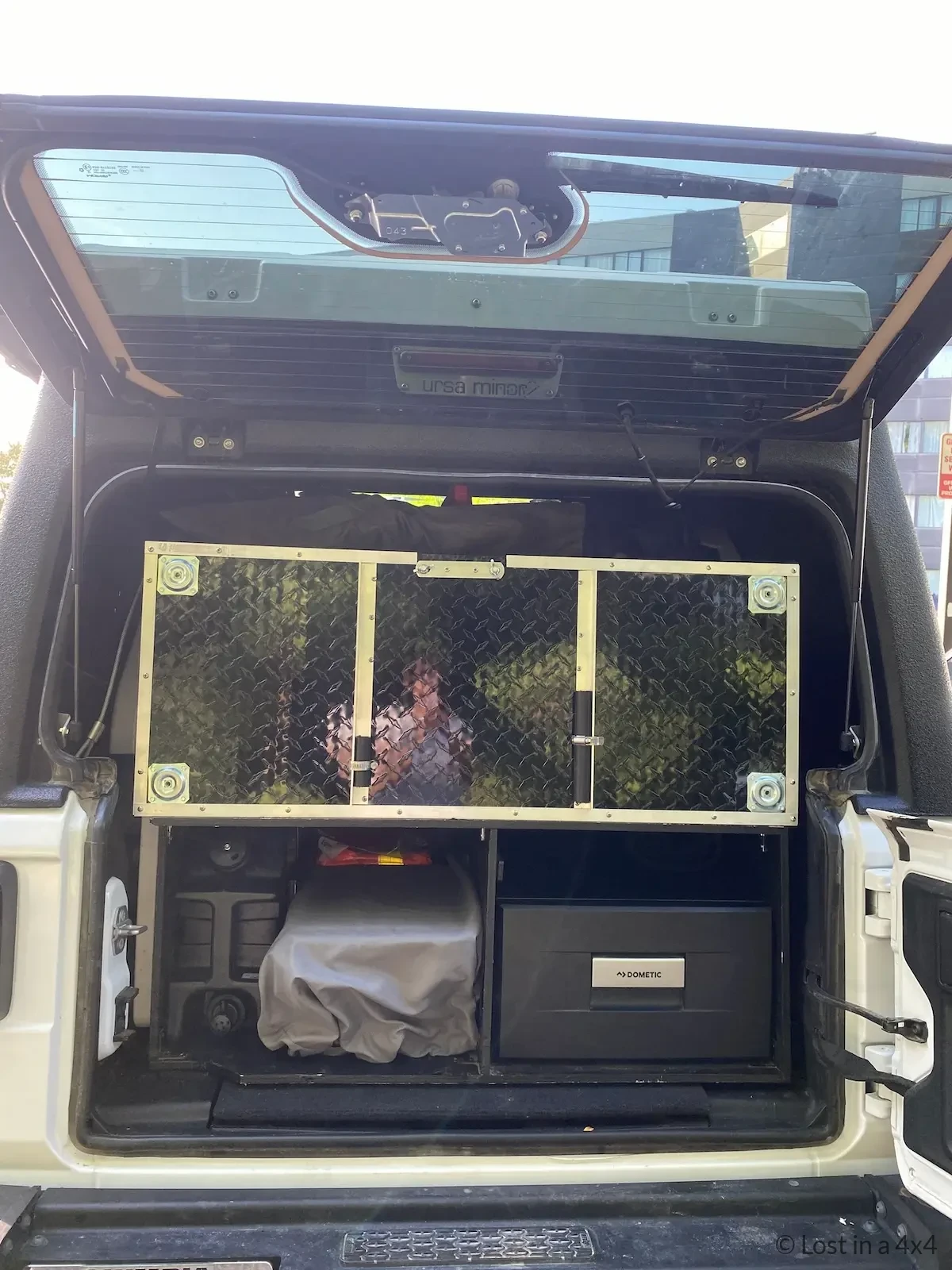 Jeep rear compartment showing fridge, Coleman stove and Lifesaver jerry can after preparation for shipping from USA to Europe