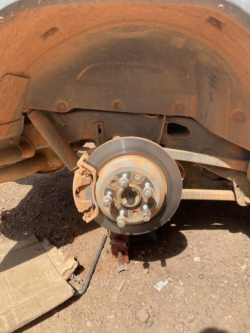 Jeep Wrangler Rubicon with flat tire removed during overland tire repair in Labé Guinea.