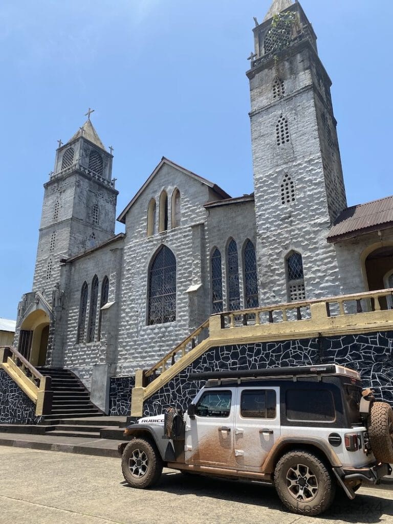 Jeep Wrangler parked in front of a church in Harper, Liberia during overland travel in West Africa.