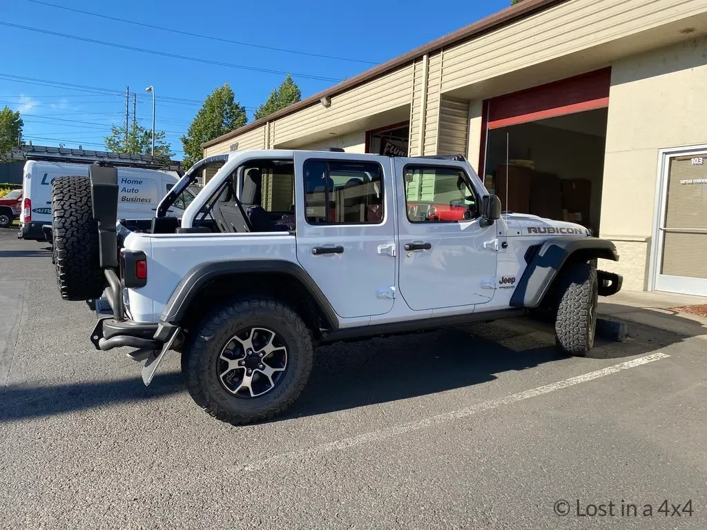 Jeep Wrangler Rubicon without soft top parked outside Ursa Minor workshop before pop-top roof camper installation in Oregon.