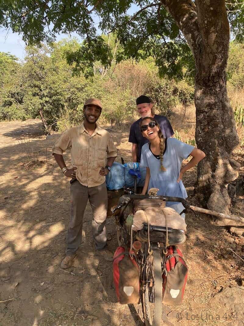 Karla Brett and Adam with fully loaded bicycle during overland Africa trip in Guinea