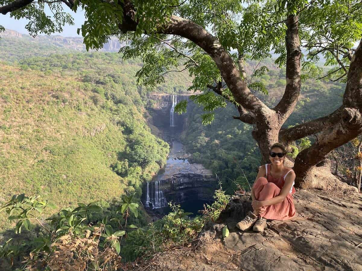 Karla sitting at viewpoint overlooking Kambadaga Waterfall in Guinea during Africa overland trip.