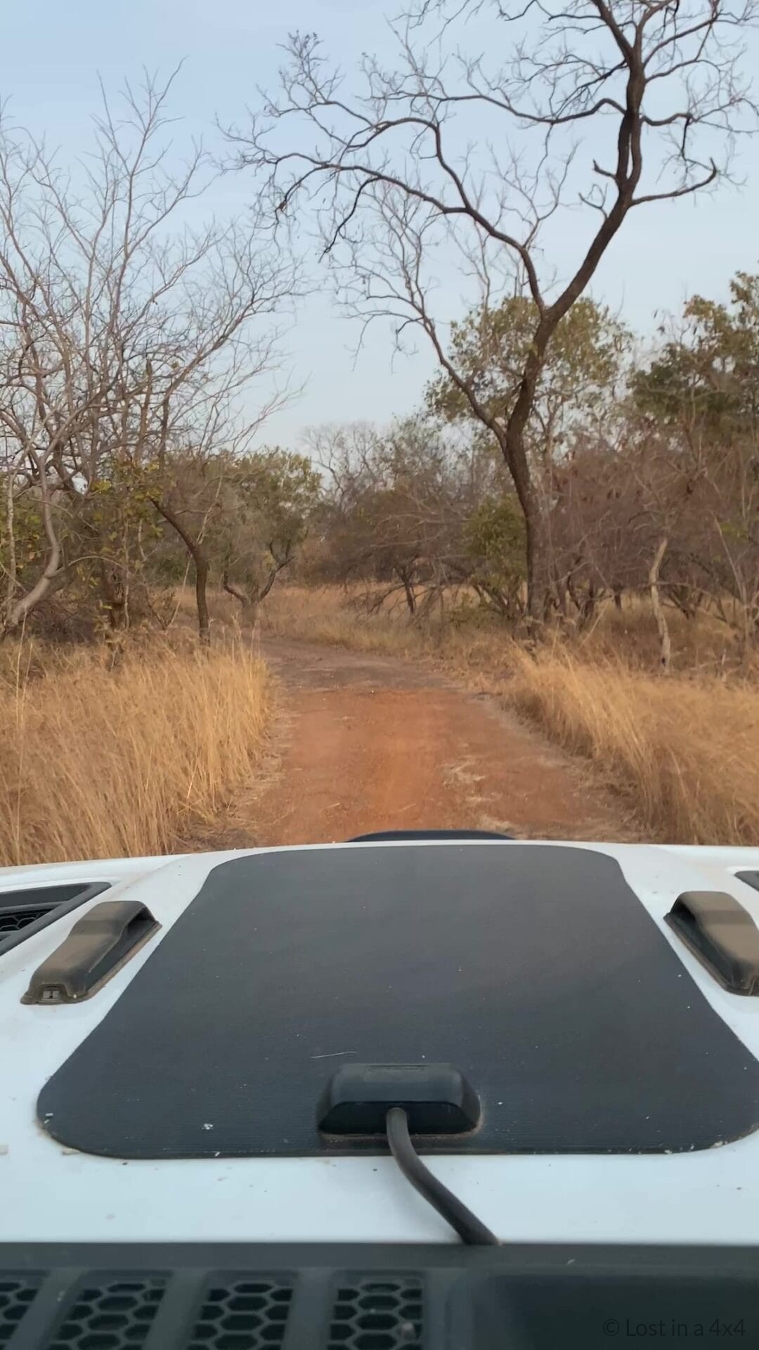Overland Jeep driving along a narrow dirt road near Niokolo-Koba National Park in Senegal