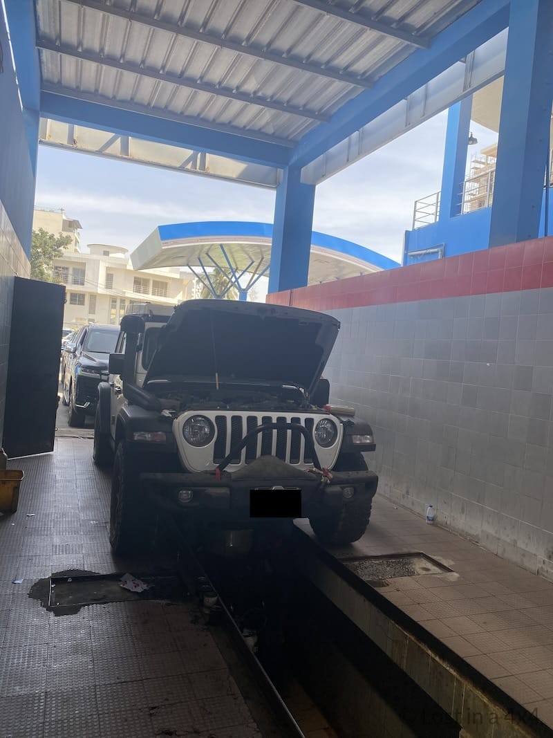 Overland Jeep positioned over an oil pit for an oil change in Dakar Senegal.