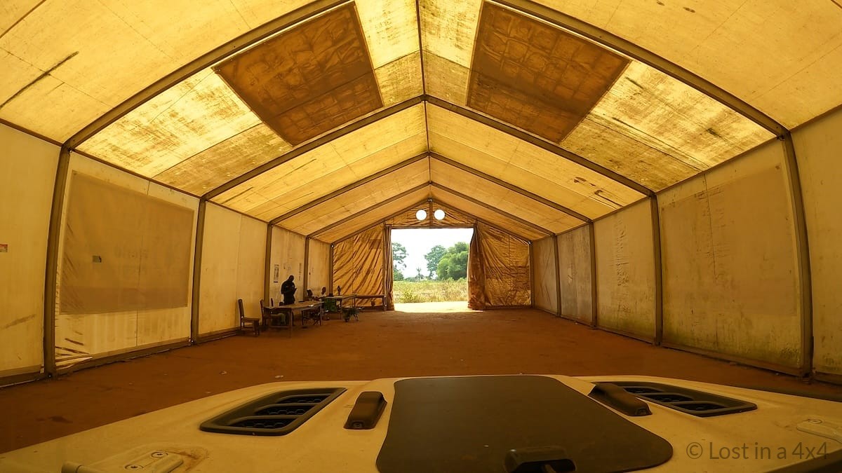 View from inside a Jeep driving through a quarantine tent on a detour road at the Sierra Leone border during overland travel.