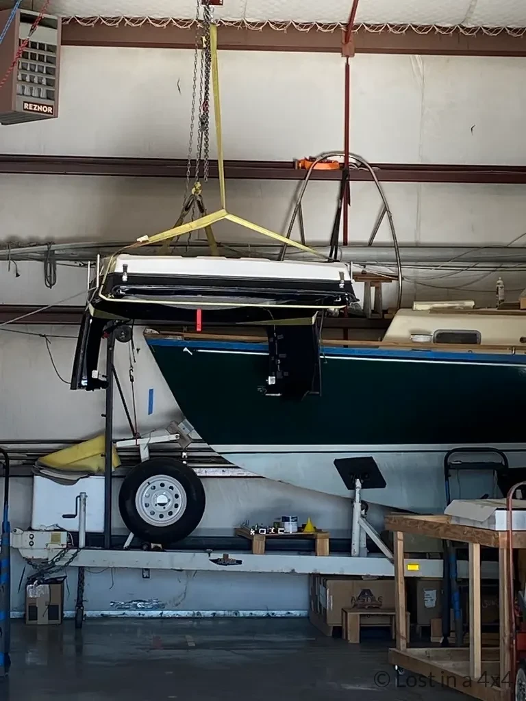 Ursa Minor pop-top roof camper suspended by cables inside a workshop during installation in Oregon, USA.