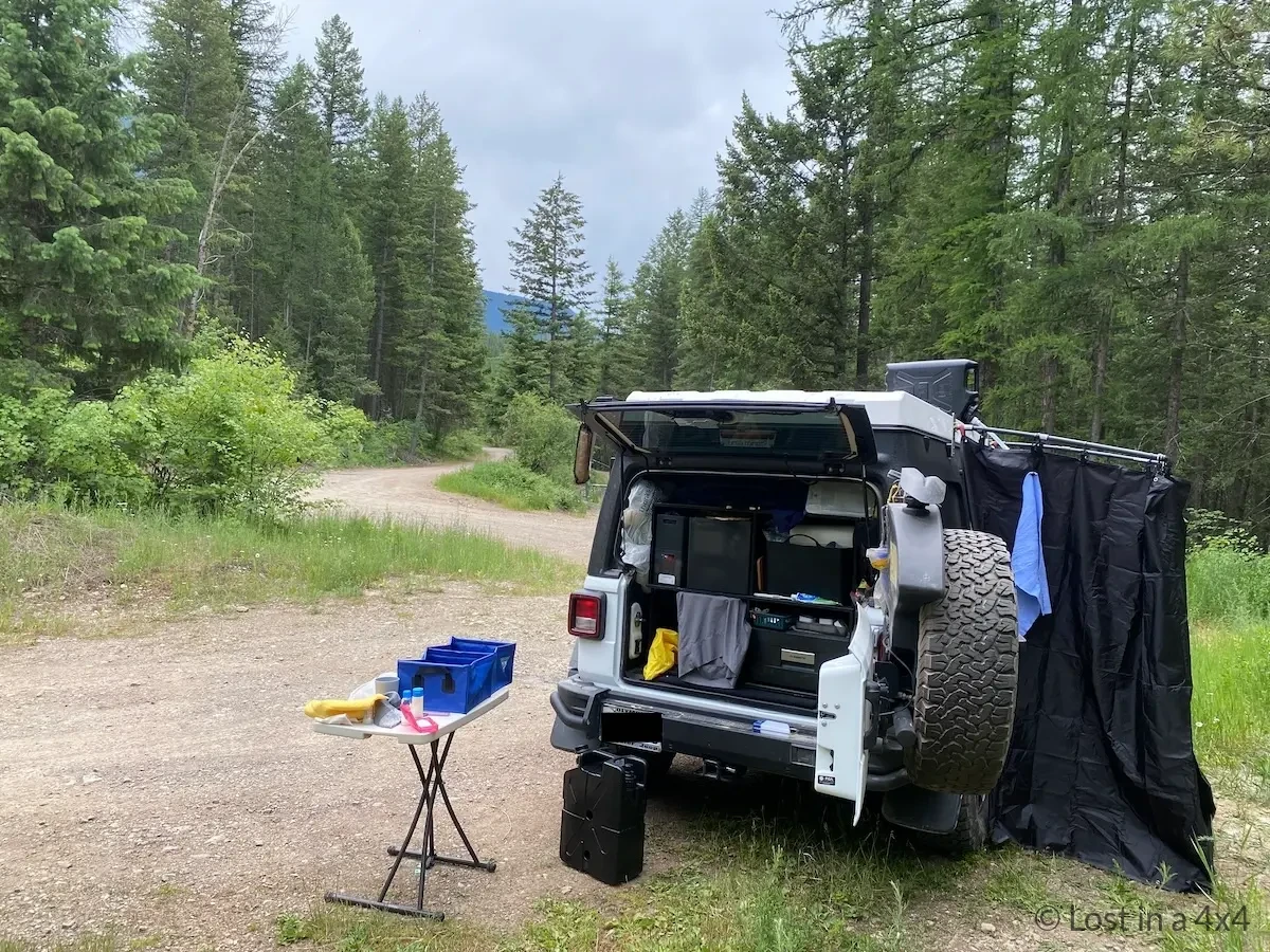 Jeep Wrangler Rubicon at a wild campsite with our overland shower setup during a road trip across the USA.