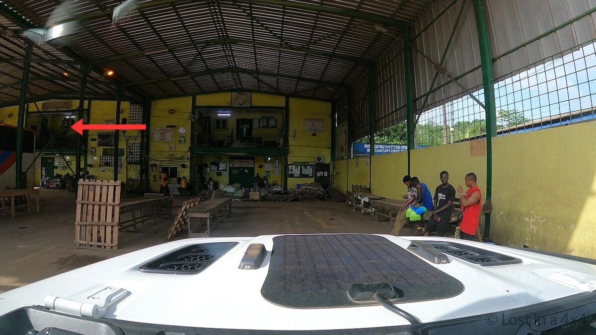 Ivory Coast Douane customs office at Noé border crossing seen from inside a vehicle during overland travel.