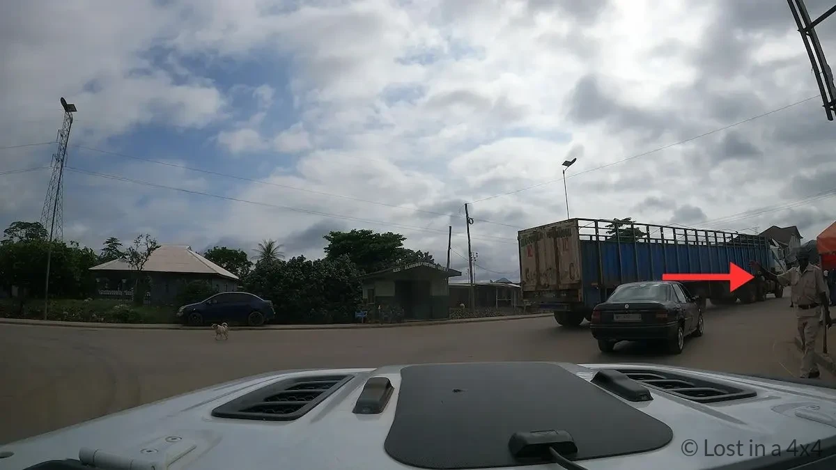 Ghana border officer collecting the entry receipt at the final checkpoint before exiting the Noé–Elubo border post.