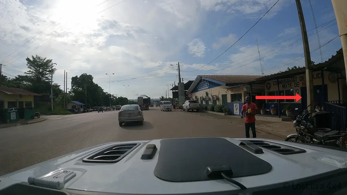 Jeep parked outside the Commissariat de Police Mixte de Noé during Ivory Coast exit process for biometrics and passport stamping.