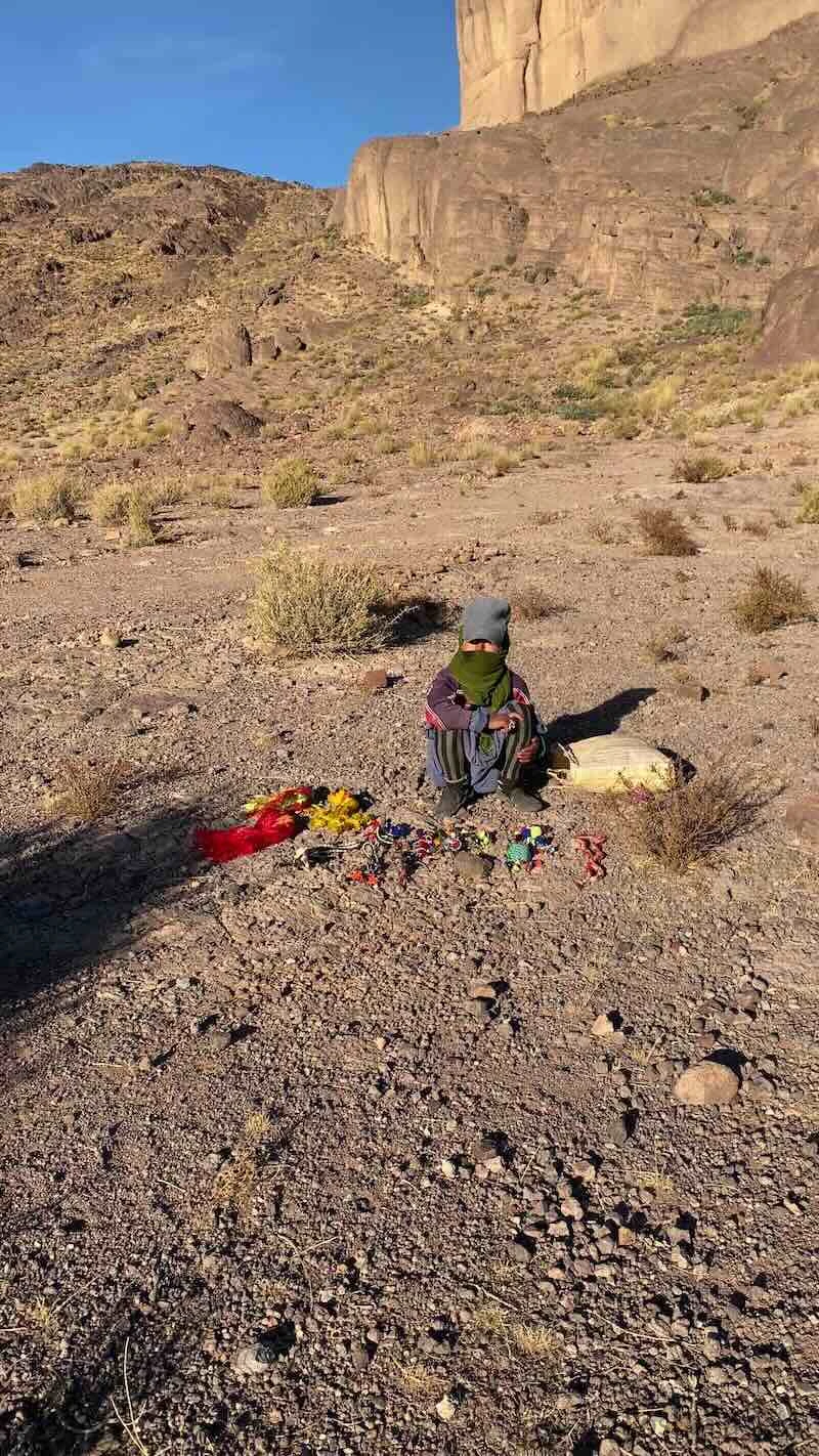 Berber girl descending a mountain near Pâte de l'Éléphant in Morocco to sell handmade trinkets.