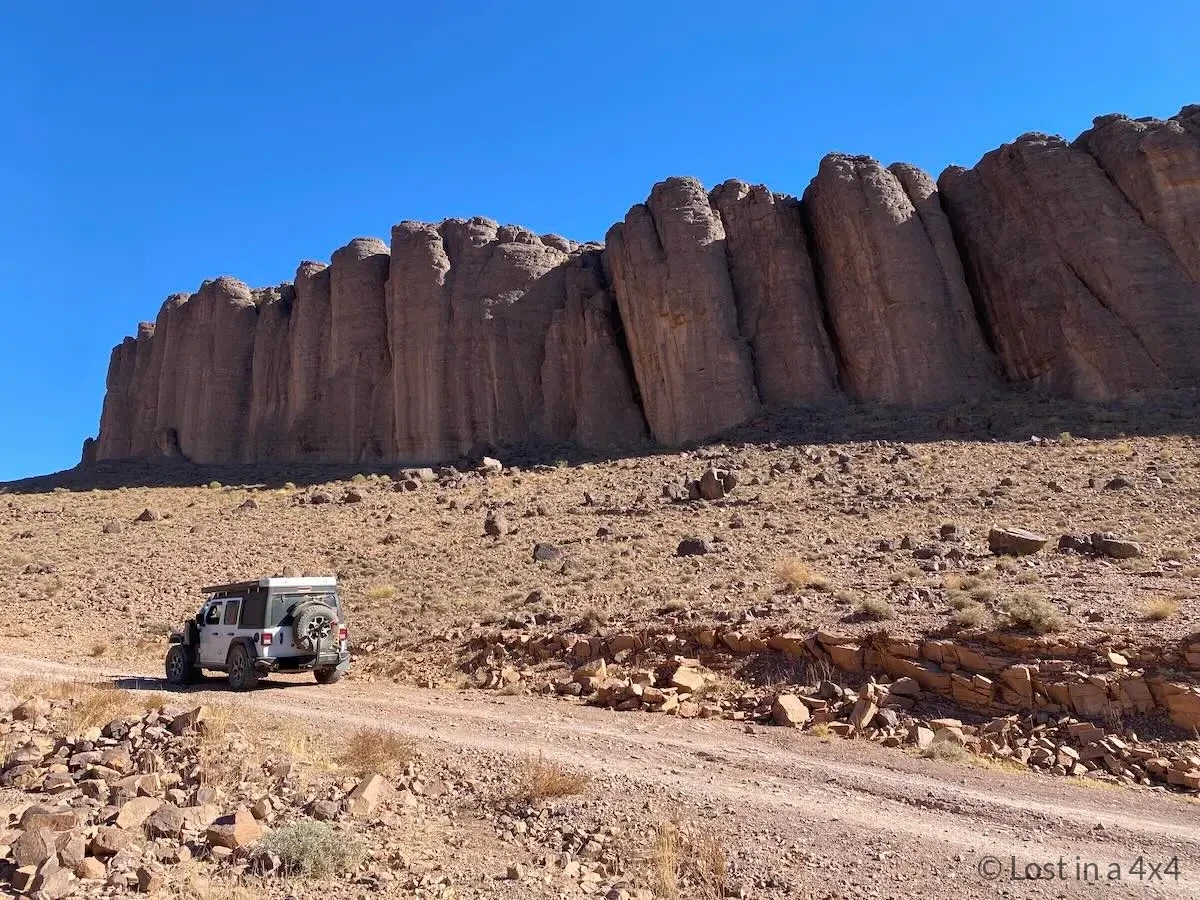 Jeep Wrangler Rubicon stopped on a remote track with finger-like rock formations in the background near Pâte de l'Éléphant, Morocco.