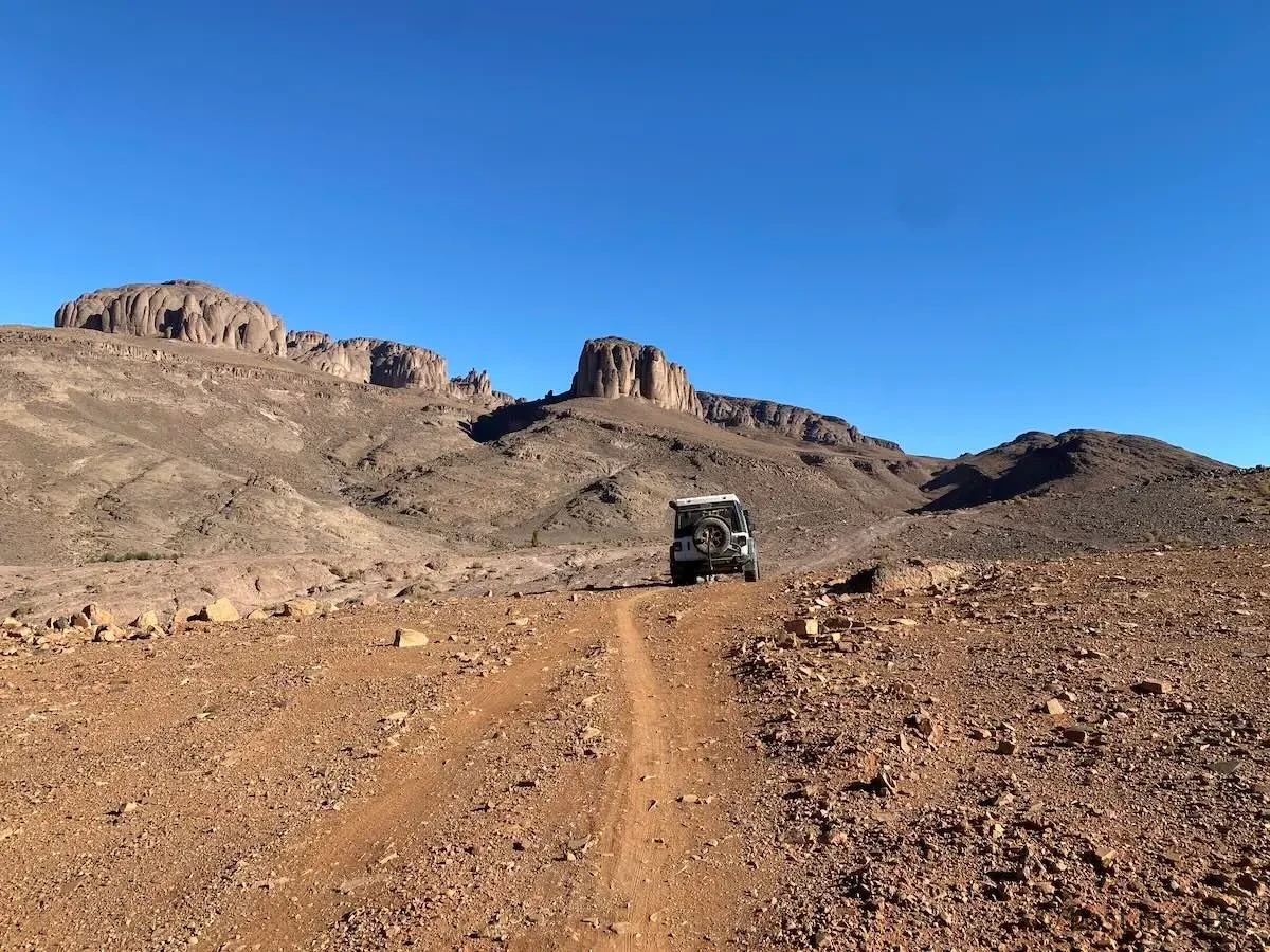 Jeep Wrangler Rubicon driving the 4x4 track around Pâte de l'Éléphant with mountain views in Morocco.