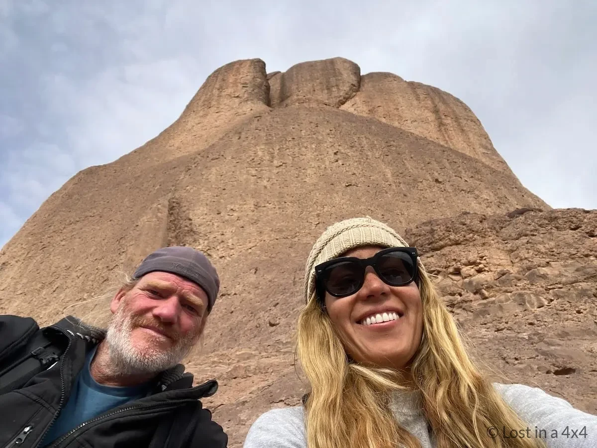 Selfie of Karla and Brett at the summit near Pâte de l'Éléphant with mountain views in Morocco.